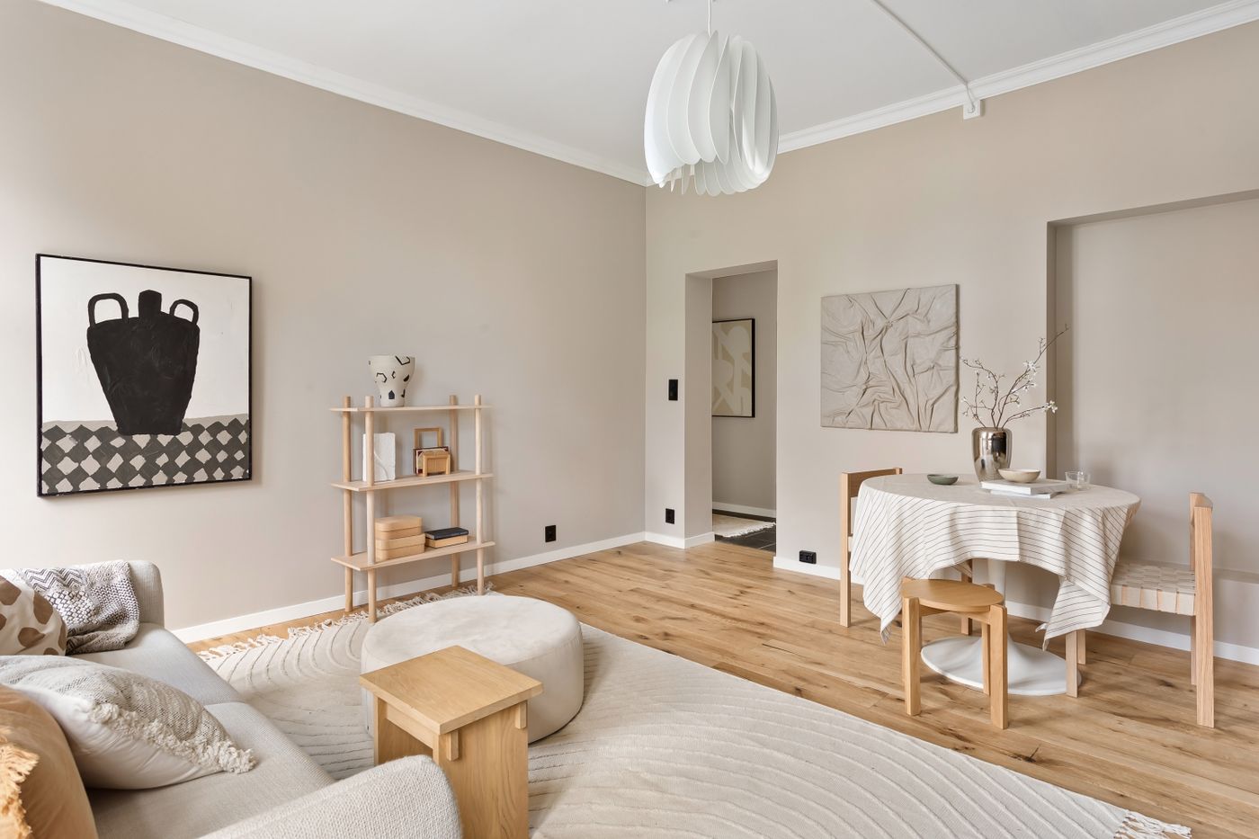 Renovated apartment living room with layered neutral tones and bespoke shelving
