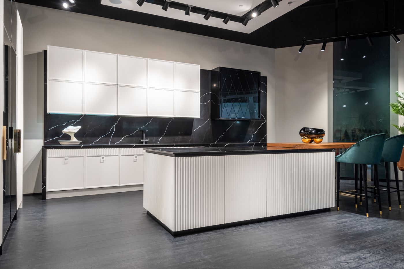 Bespoke kitchen with a dark stone island and handleless cabinetry