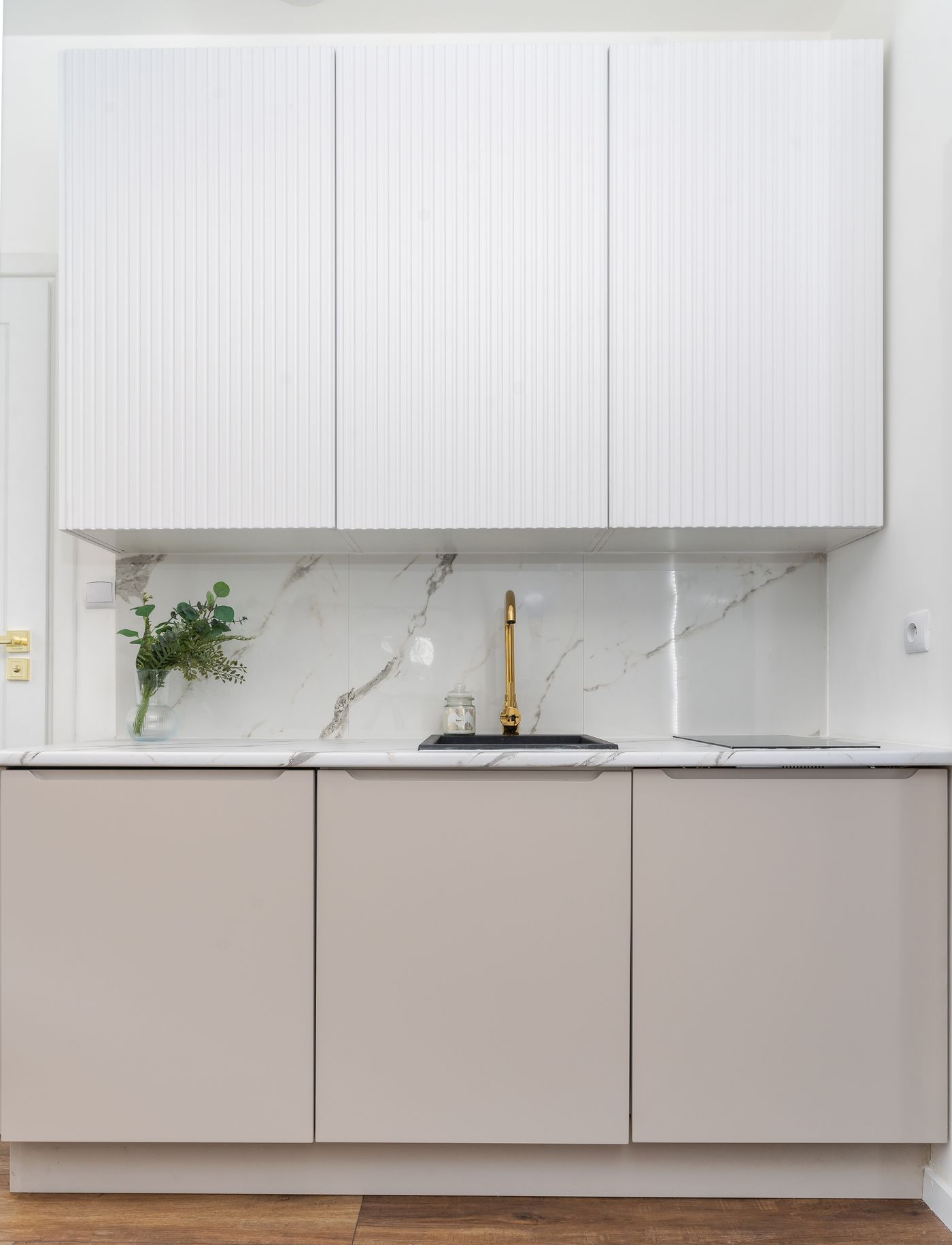 Bespoke kitchen with a marble backsplash and handleless units
